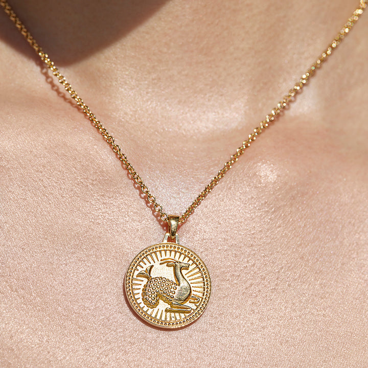 Close Up of Ethical Gold Capricorn Pendant Being Worn Against a Woman's Collarbone