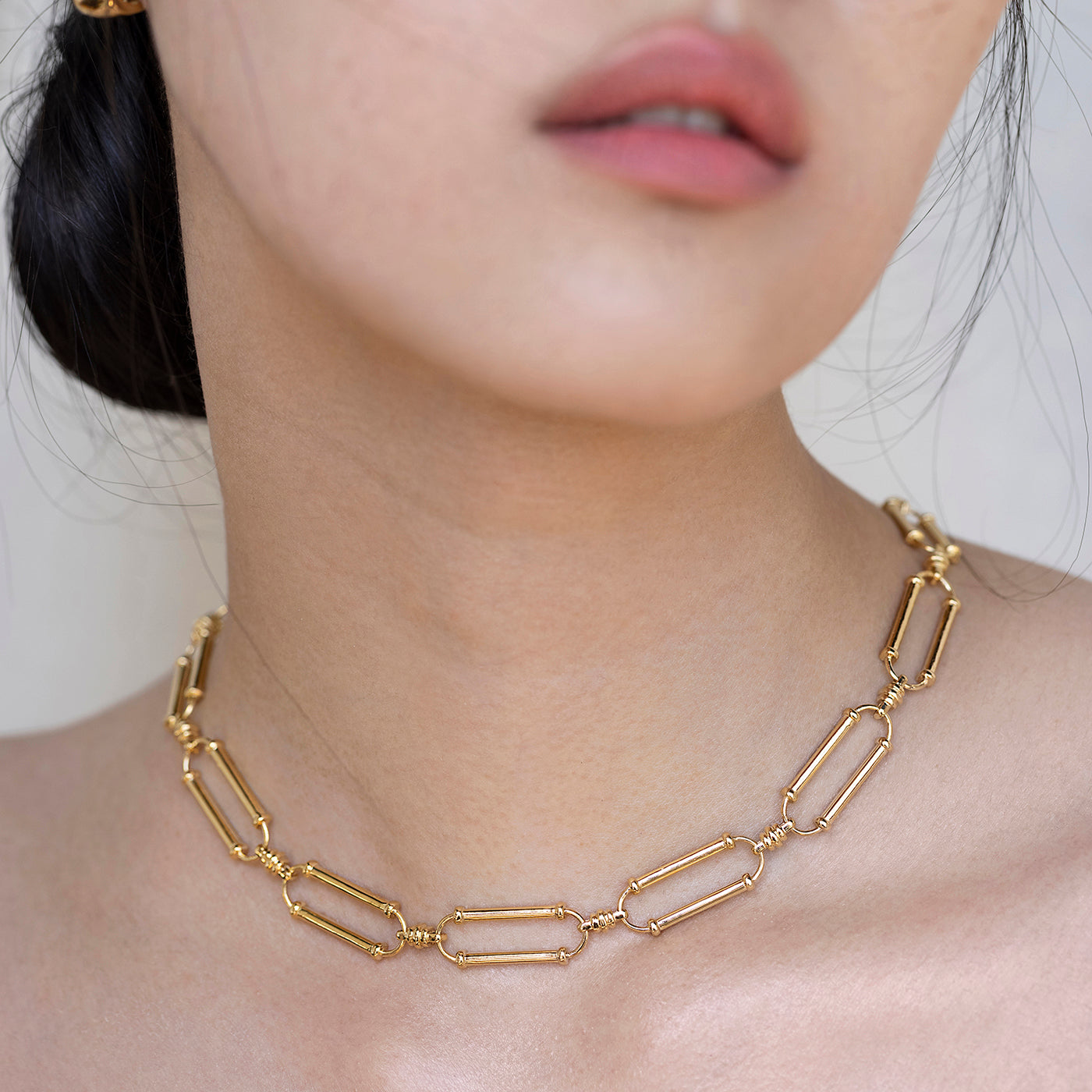 Close Up of Woman's Neck Wearing an Ethical Gold Oval Link Necklace Hanging Just to the Collarbone