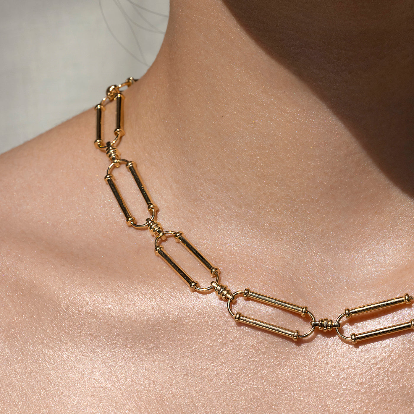 Close up of links on our ethical gold oval link necklace worn against a woman's skin