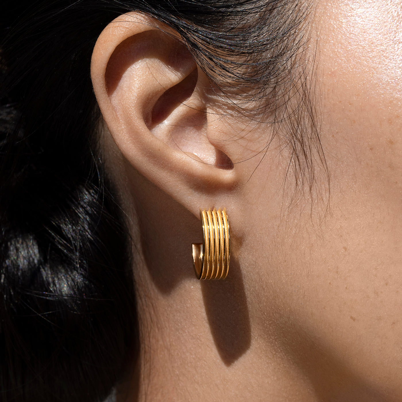 Close up of Woman's Ear Wearing a Small Ridged Ethical Gold Hoop Earring