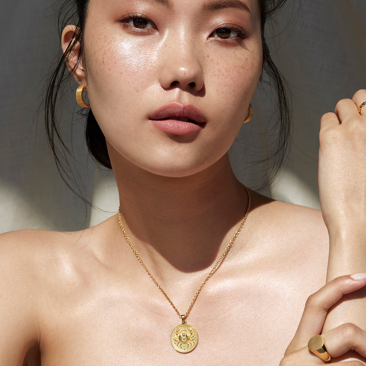 Woman Facing the Camera Wearing Cancer Ethical Gold Pendant and Ethical Gold Chain 