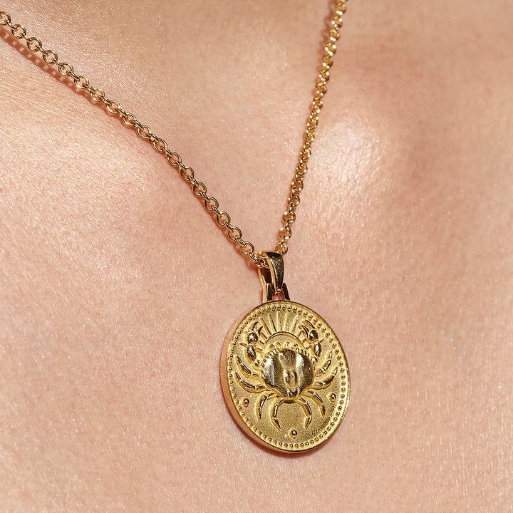 Close up of Cancer Ethical Gold Pendant Necklace Being Worn Against Skin