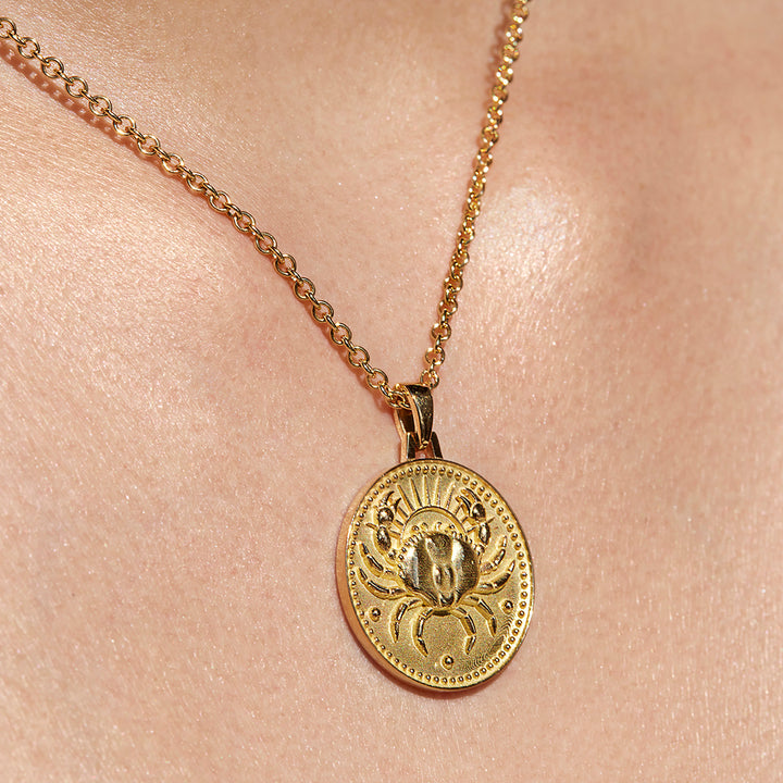 Close up of Cancer Ethical Gold Pendant Necklace Being Worn Against Skin