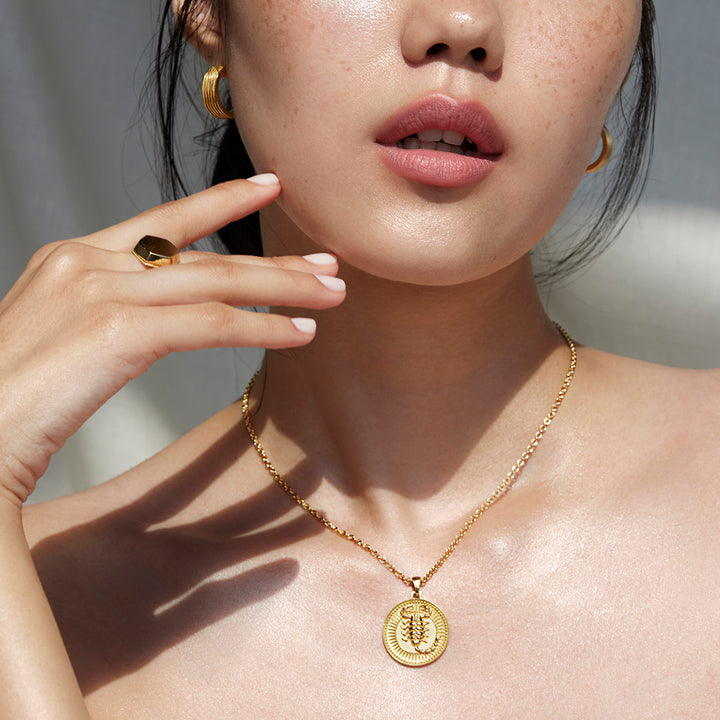 Woman from Nose to Upper Chest Wearing Ethical Gold Scorpio Pendant Necklace